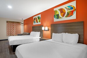 A hotel room with two beds, a wooden headboard, a nightstand, and a wall with abstract art. - Best Western Statesville Inn (Statesville)