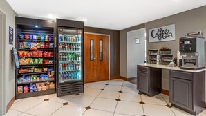 A hotel lobby with a vending machine, a refrigerator, a coffee bar, and a door. - Best Western Statesville Inn (Statesville)