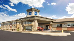 A hotel with a central tower, multiple windows, and a parking lot.