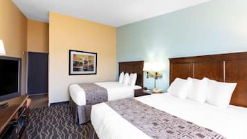 A hotel room with two beds, a TV, a desk, and a framed picture on the wall.
