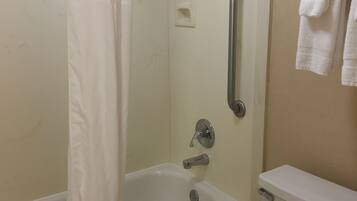 A bathroom with a bathtub, a shower, a toilet, and a towel rack.