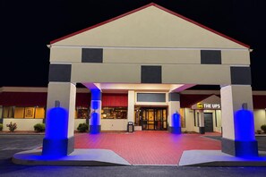 A hotel with a red roof, a UPS store, and blue lighting on the pillars. - Ramada by Wyndham Santee I-95 (Santee)