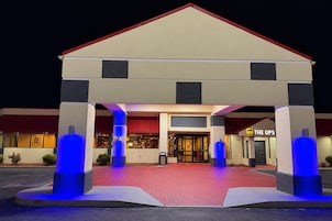 Un hotel con techo rojo, una tienda UPS e iluminación azul en los pilares.
