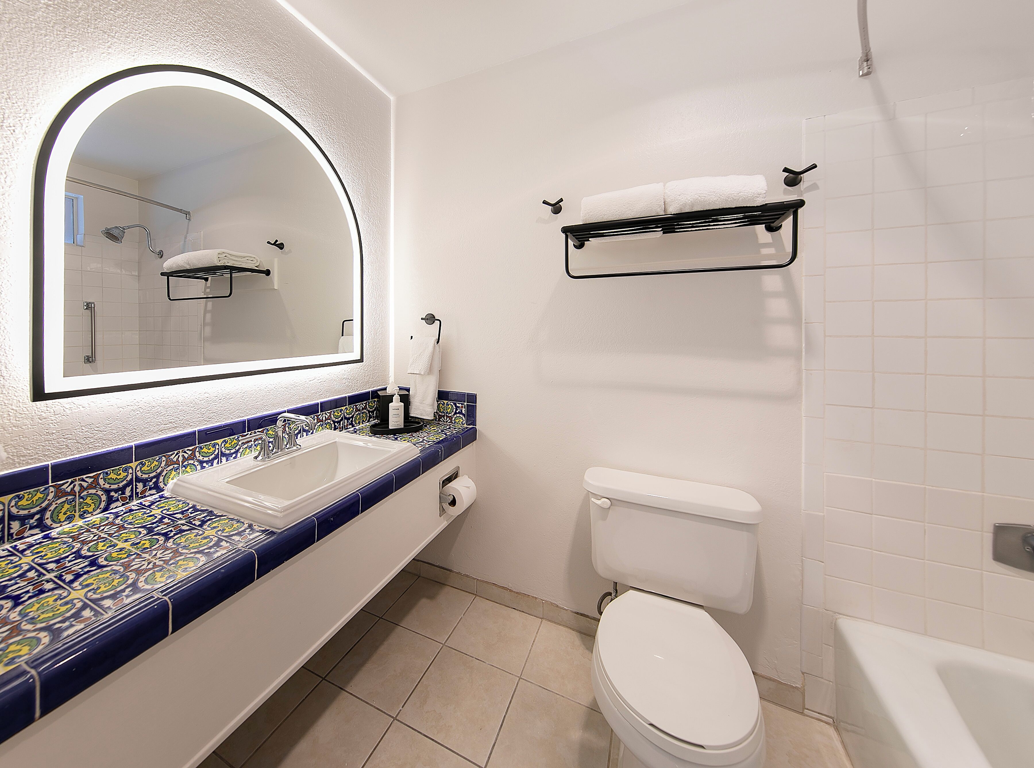 Un baño con un lavamanos blanco, un espejo, un inodoro y una bañera.