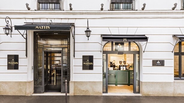 A building with a 'MATHIS' sign at the entrance, a visible entrance, and a 'COUTUMES' sign next to it. - Hôtel Mathis (Paris)