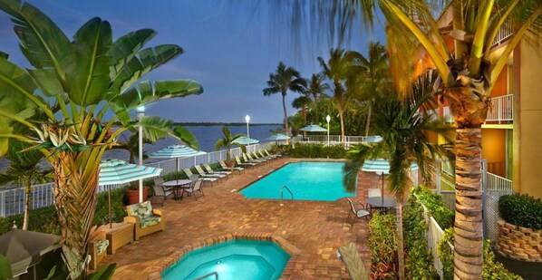 Una piscina al aire libre, sombrillas, sillones reclinables de piscina