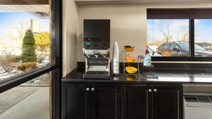 A kitchen counter with a coffee machine, a coffee pot, and a water dispenser.
