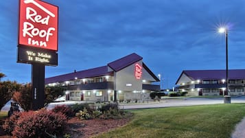 A Red Roof Inn with a large sign, a lobby, and a parking area.