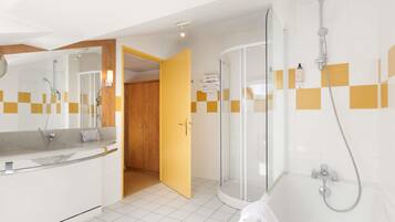A modern bathroom with a shower, a bathtub, and a vanity with a mirror.
