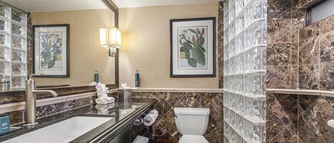 A bathroom with a sink, toilet, and shower area.