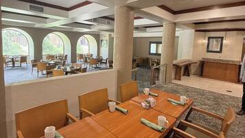 A conference room with a long table, chairs, and a view of the outdoor patio area.