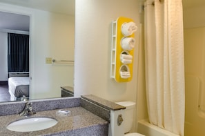 Bathroom features a granite countertop sink, toilet, and shower with a showerhead.