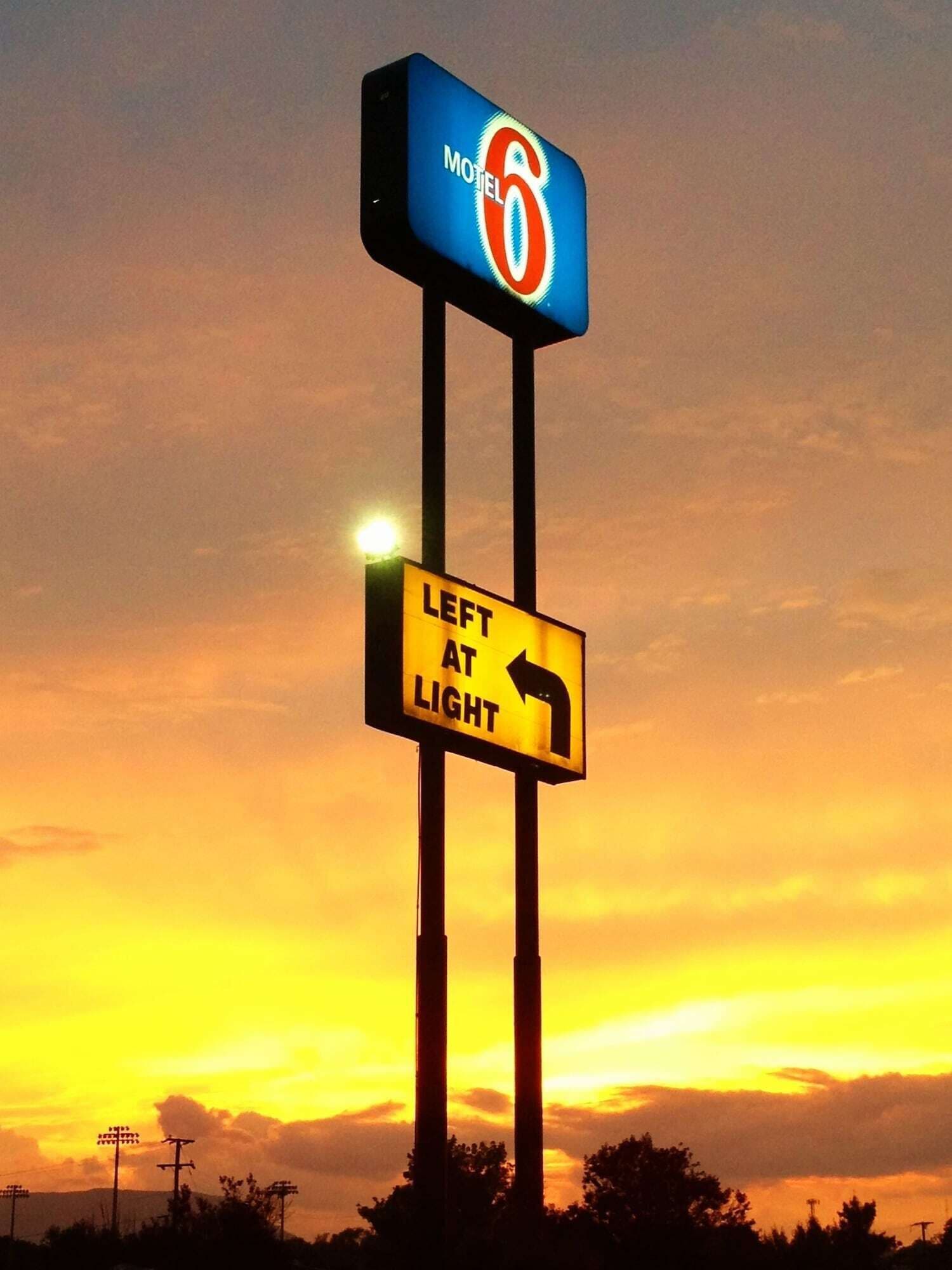 A motel sign with a directional sign below it.