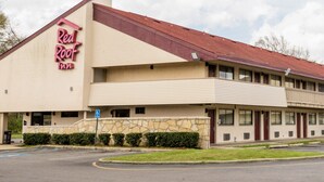 Un hôtel Red Roof Inn avec une structure à deux étages, une façade en pierre et un toit rouge.