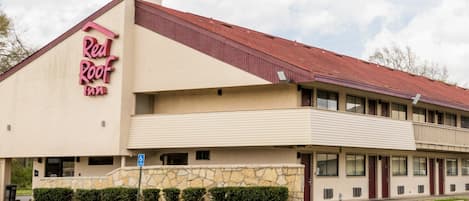 A Red Roof Inn with a two-story structure, a stone facade, and a red roof.
