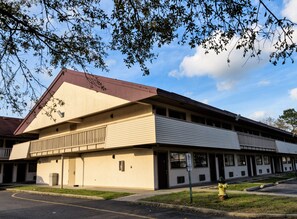 A two-story building with a flat roof and a fire hydrant in the foreground. - Red Roof Inn Lafayette, LA (Lafayette)
