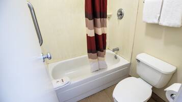 Une salle de bain avec une baignoire, des toilettes et un rideau de douche.