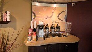 Un espace bar équipé d’une machine à café, d’un mixeur et de divers condiments.