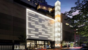 A modern building with a large illuminated facade and a visible entrance with glass doors. - W Toronto (Toronto)