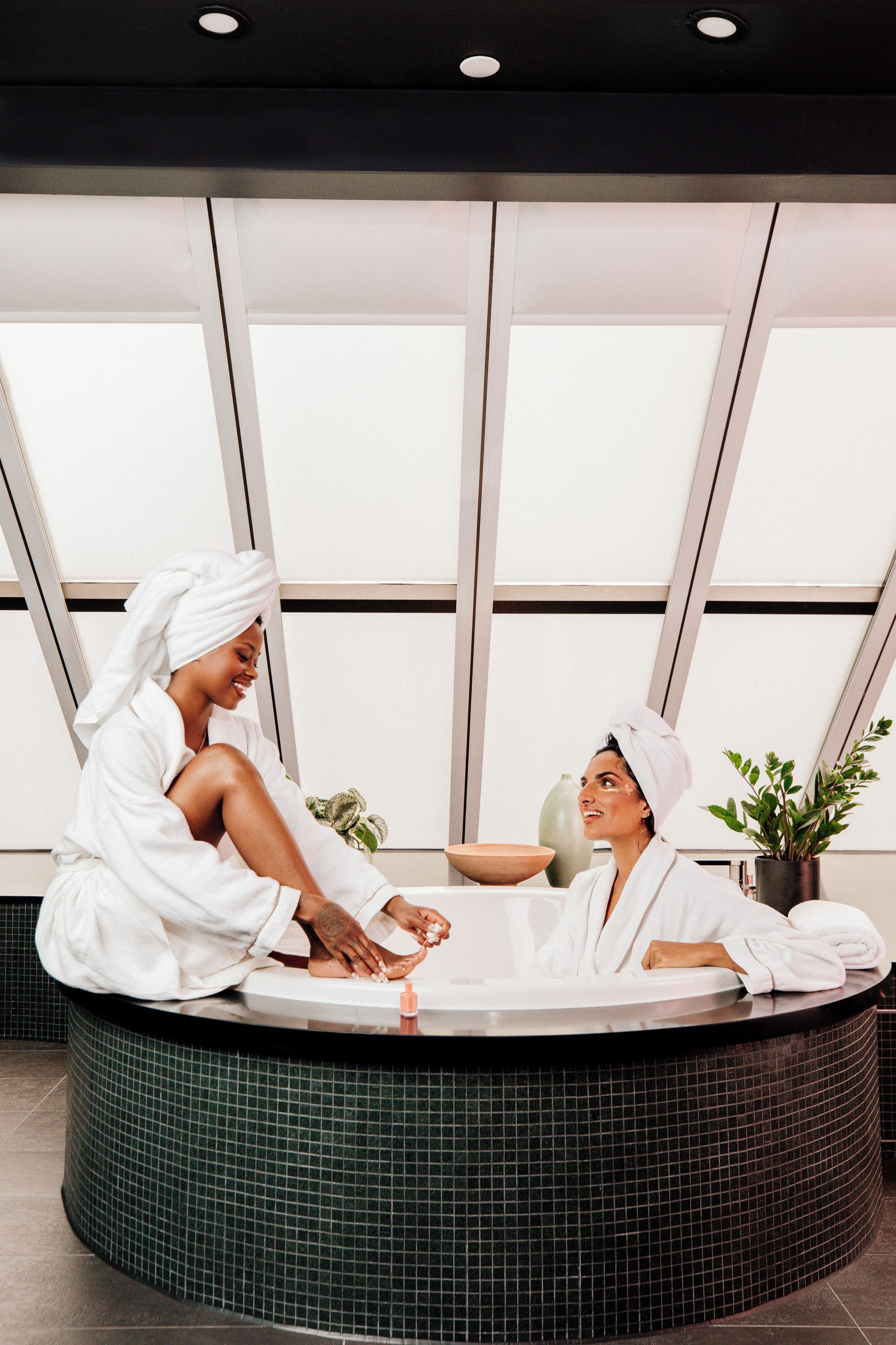 A spa setting with a reception area, a large window, and a plant.