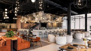 A modern interior with a bar area, seating arrangements, and a staircase. - W Toronto (Toronto)