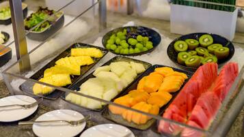 A buffet with various fruits and vegetables on trays.
