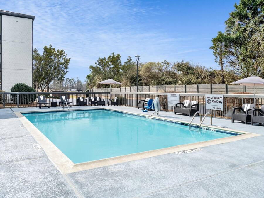 Piscina con sillas de descanso y un letrero que indica prohibido bucear.