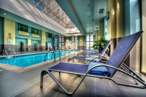 Una piscina techada, sillones reclinables de piscina