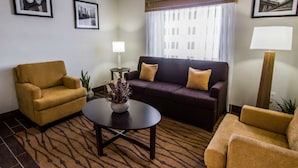 A living room with a sofa, two armchairs, a coffee table, and a lamp.