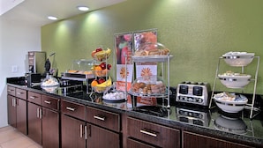 A buffet setup with various food items and a toaster.