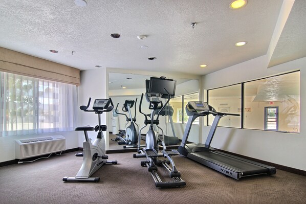 A gym with treadmills, elliptical machines, and stationary bikes.