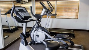 An indoor gym with exercise equipment, including a stationary bike and elliptical machine.