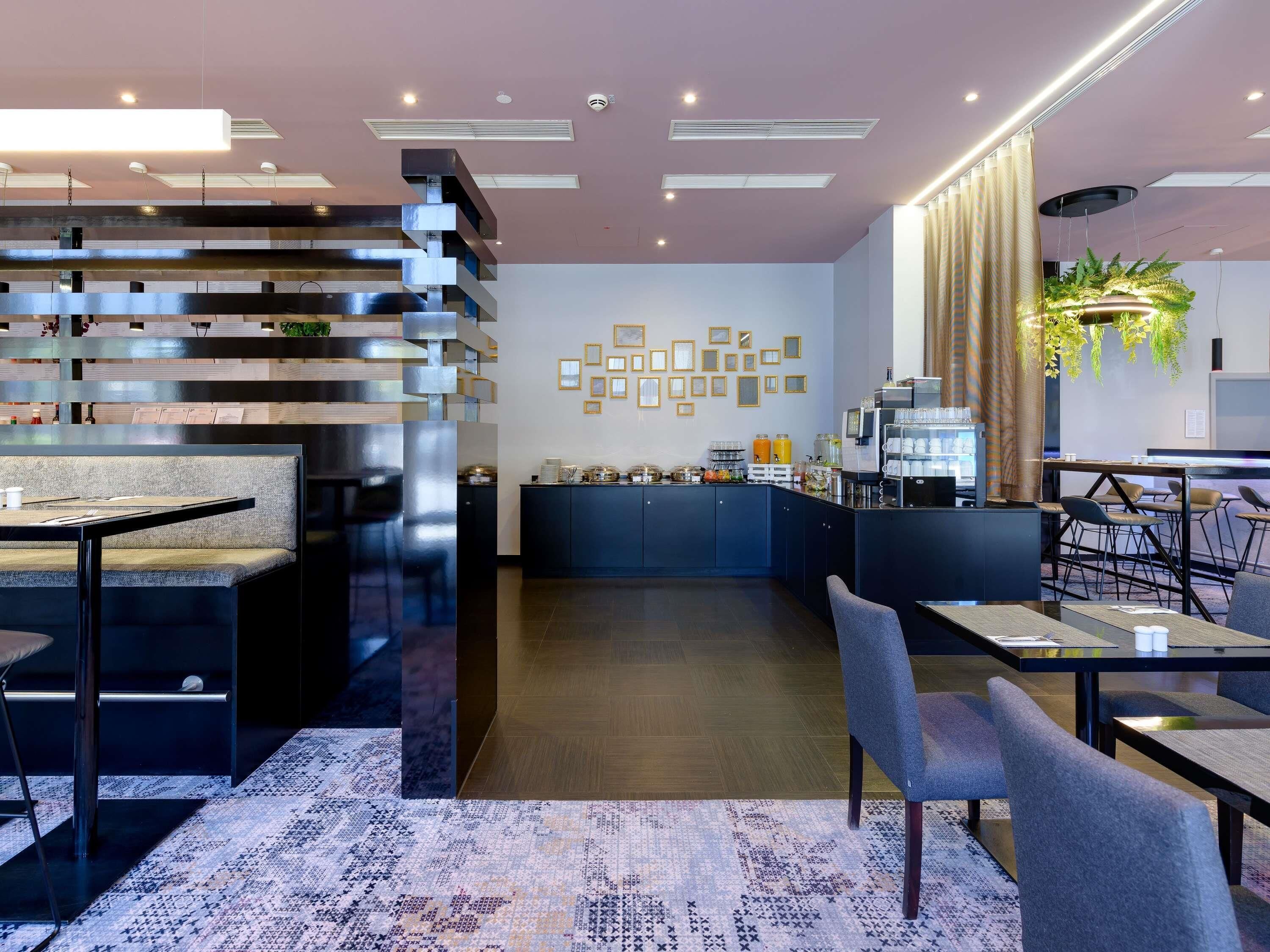 Un interior moderno con escalera, zona de estar, cocina y bar.