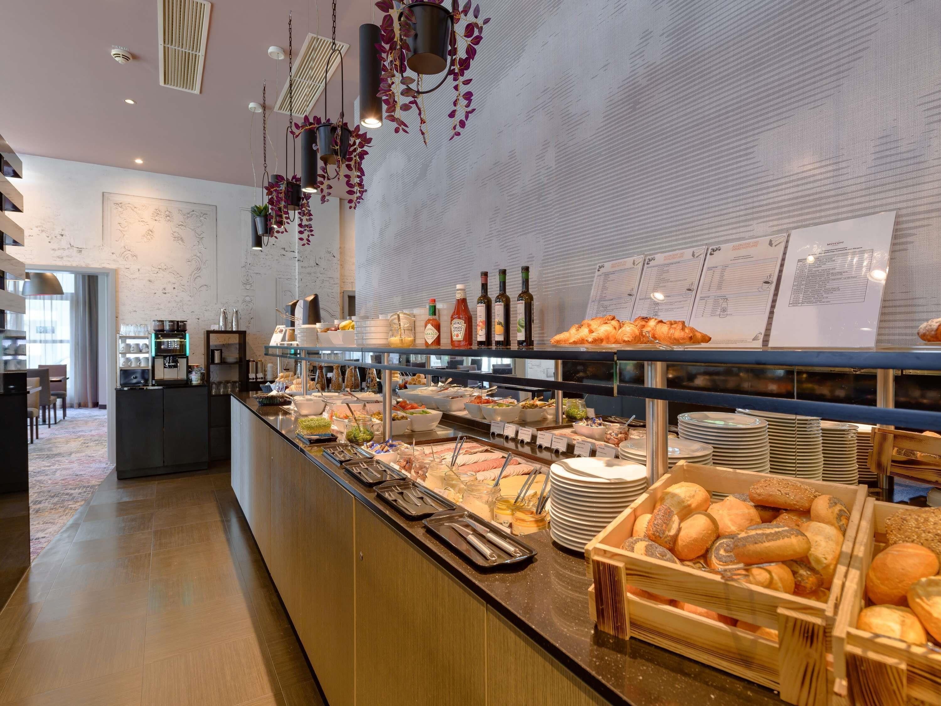Um buffet de café da manhã com diversas opções de alimentos, um espaço para café e uma área de estar com vista.