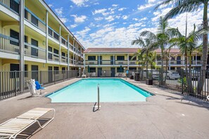 A hotel with a swimming pool, multiple balconies, and palm trees. - La Quinta Inn by Wyndham Costa Mesa / Newport Beach (Costa Mesa)