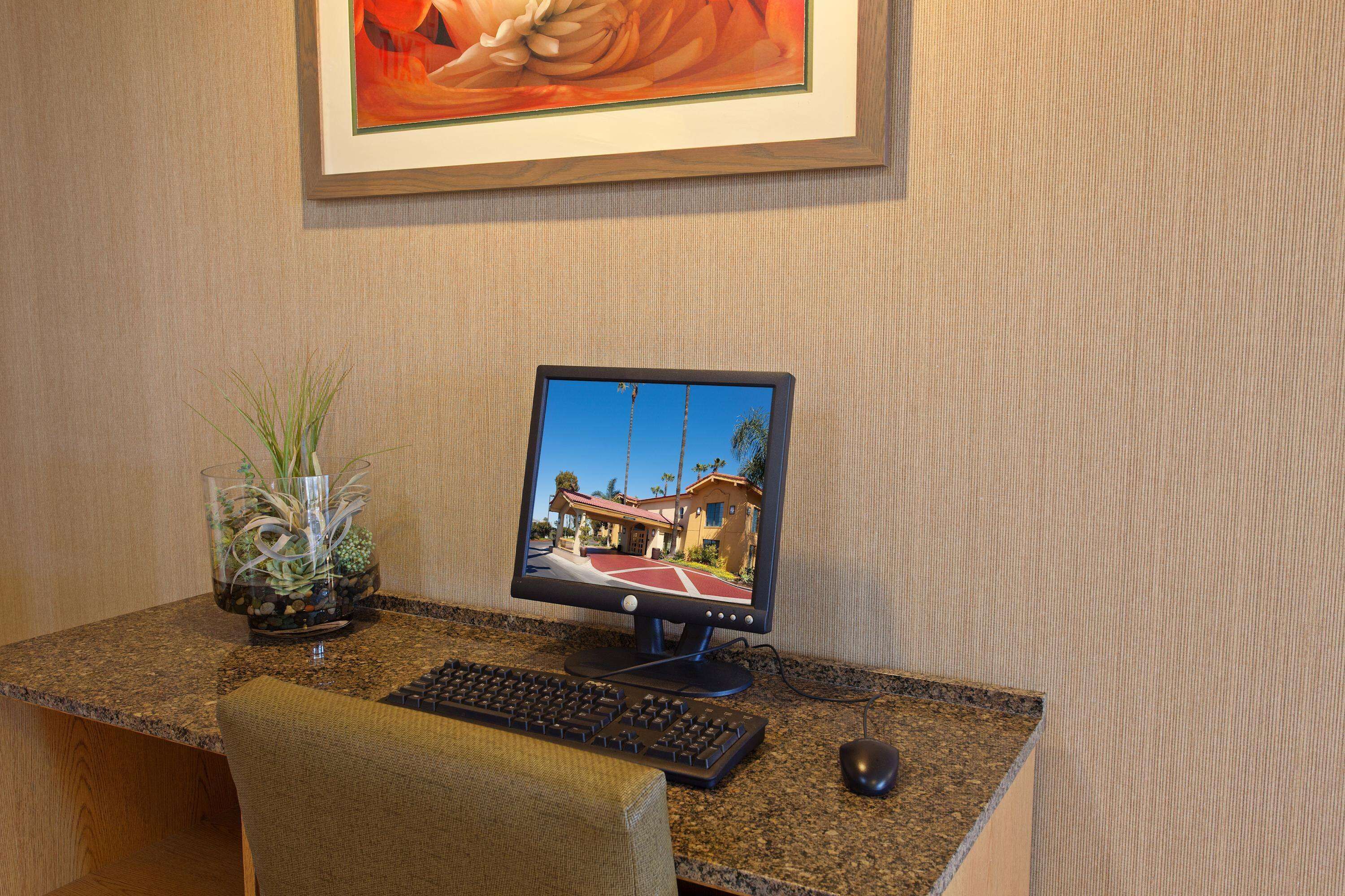 Un ordinateur de bureau installé sur un comptoir en granit, avec un écran, un clavier et une souris.