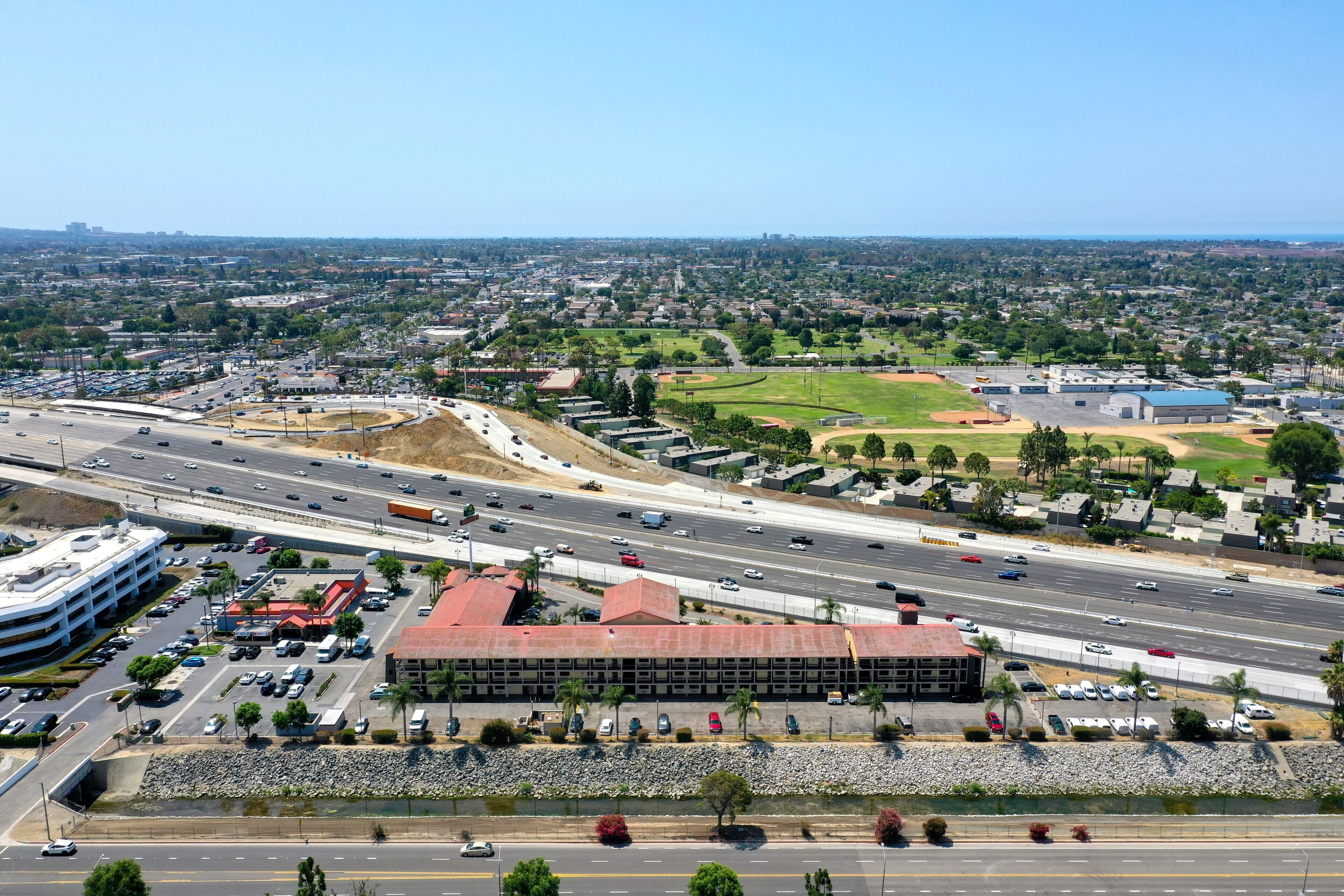 A multi-level parking structure with a central building, a highway, and surrounding residential areas.