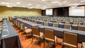 A conference room with rows of tables and chairs, equipped with water bottles and nameplates. - Holiday Inn Airport - Portland by IHG (Portland)