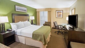 A hotel room with a bed, desk, chair, television, and two lamps. - Holiday Inn Airport - Portland by IHG (Portland)