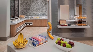 A modern hotel breakfast area with a buffet setup, including a variety of fruits, cereals, and pastries. - Delta Hotels by Marriott Richmond Downtown (Richmond)