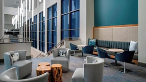 A modern hotel lobby with a seating area, large windows, and a staircase. - Delta Hotels by Marriott Richmond Downtown (Richmond)