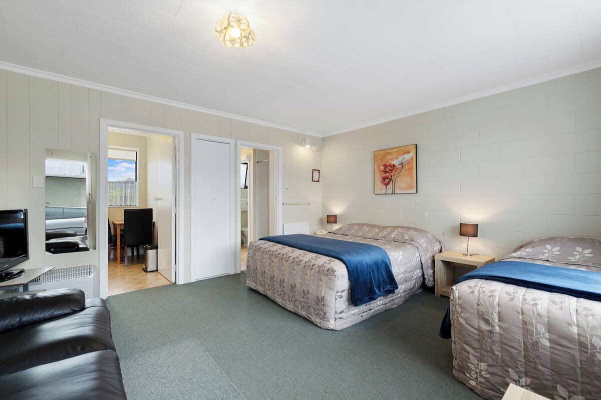 Ein Hotelzimmer mit Bett, Schreibtisch, Stuhl und Fernseher.