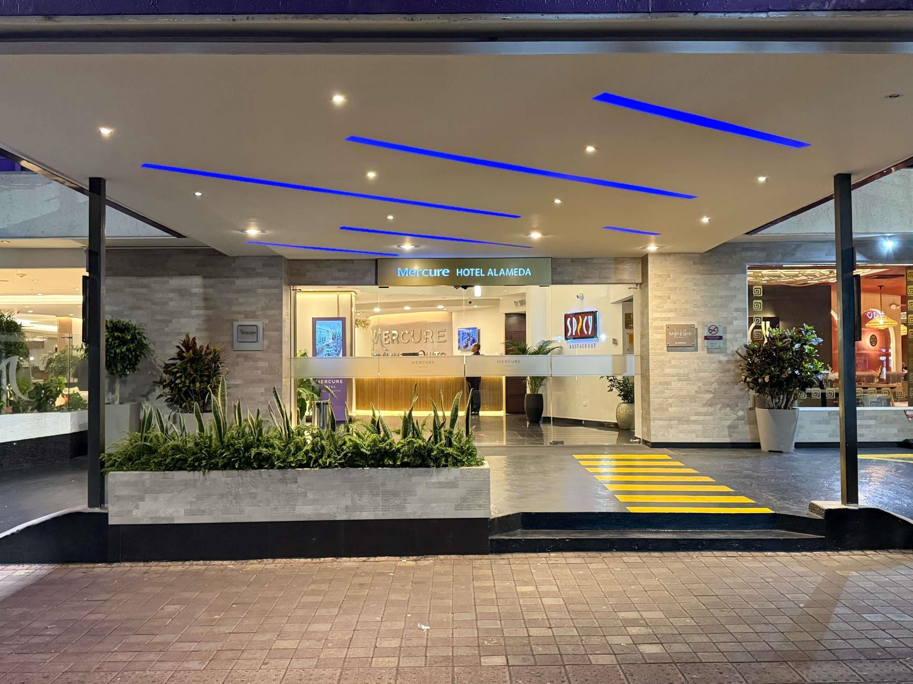 El exterior del Hotel Mercure Alameda, con una zona de recepción, un restaurante llamado SPICE y un paso de peatones claramente señalizado.