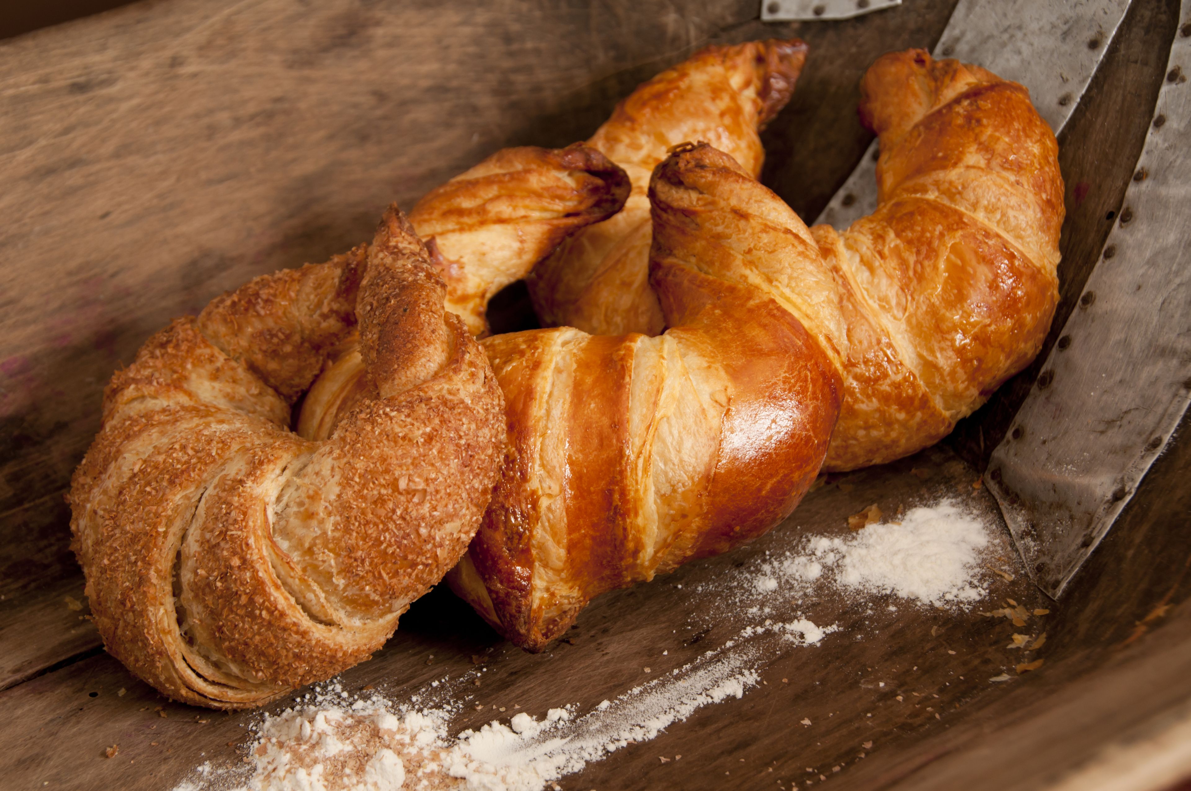A wooden surface with a pastry and a knife.