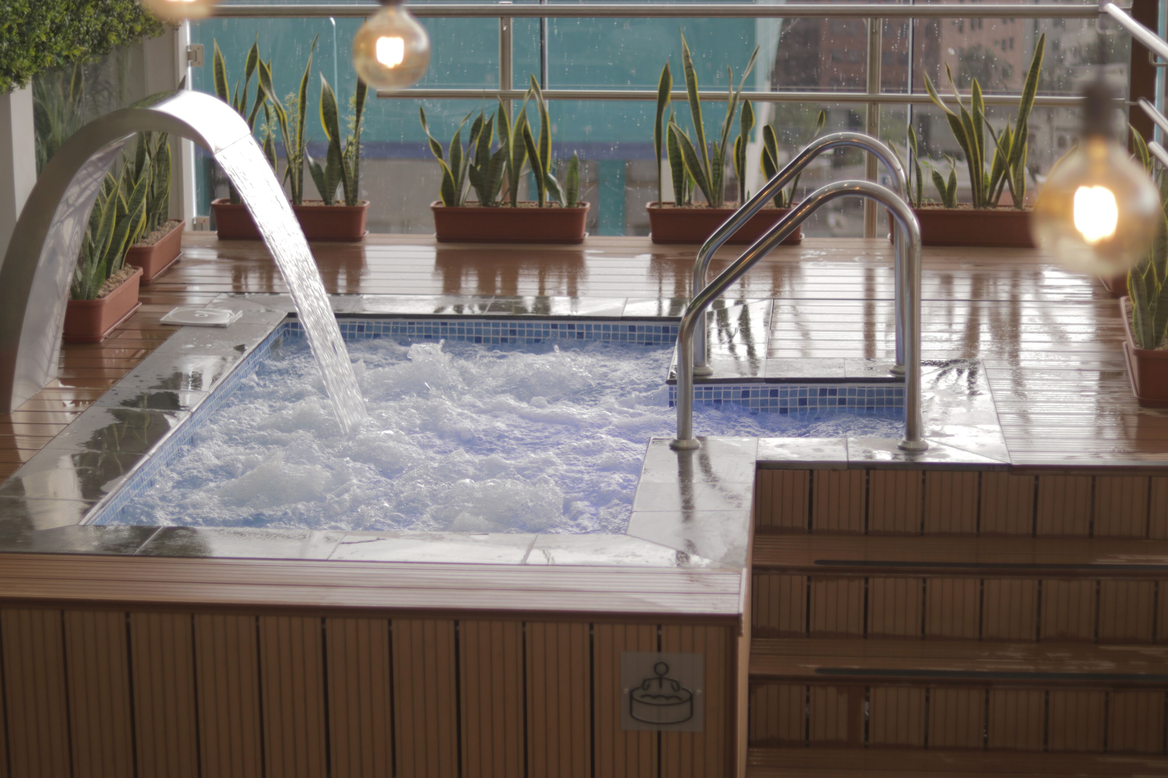 A hot tub with a clear view of the cityscape through the window.