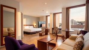 A hotel room with a bed, a desk, a chair, a sofa, and a TV. - Mercure Alameda Quito (Quito)