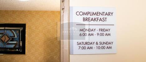 Señal que indica los horarios del desayuno de cortesía en un hotel.