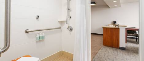 A modern bathroom with a shower, a toilet, and a sink.