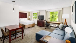 A hotel room with a bed, a desk with a chair, a sofa, a TV, and a lamp. - Residence Inn by Marriott Seattle Northeast-Bothell (Bothell)