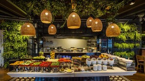 Montaje de bufé con diferentes opciones de comida y una zona central de servicio.